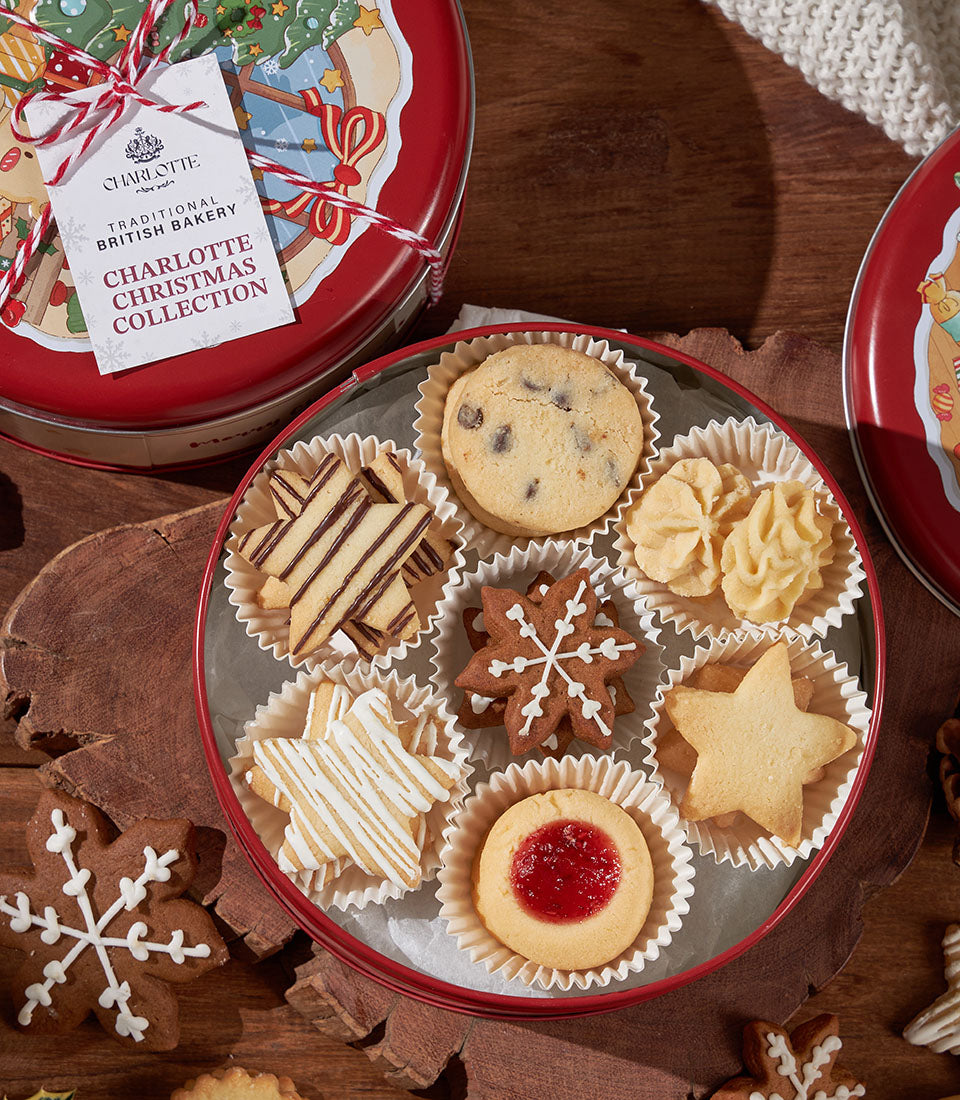 Festive Christmas biscuit collection in red tin with chocolate chip, gingerbread, and iced star cookies