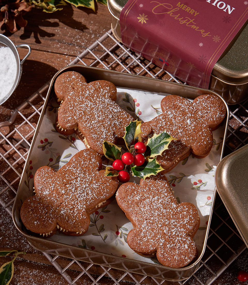 Cream-filled gingerbread cookies dusted with powdered sugar in gold tin with holly sprig, Christmas gift set
