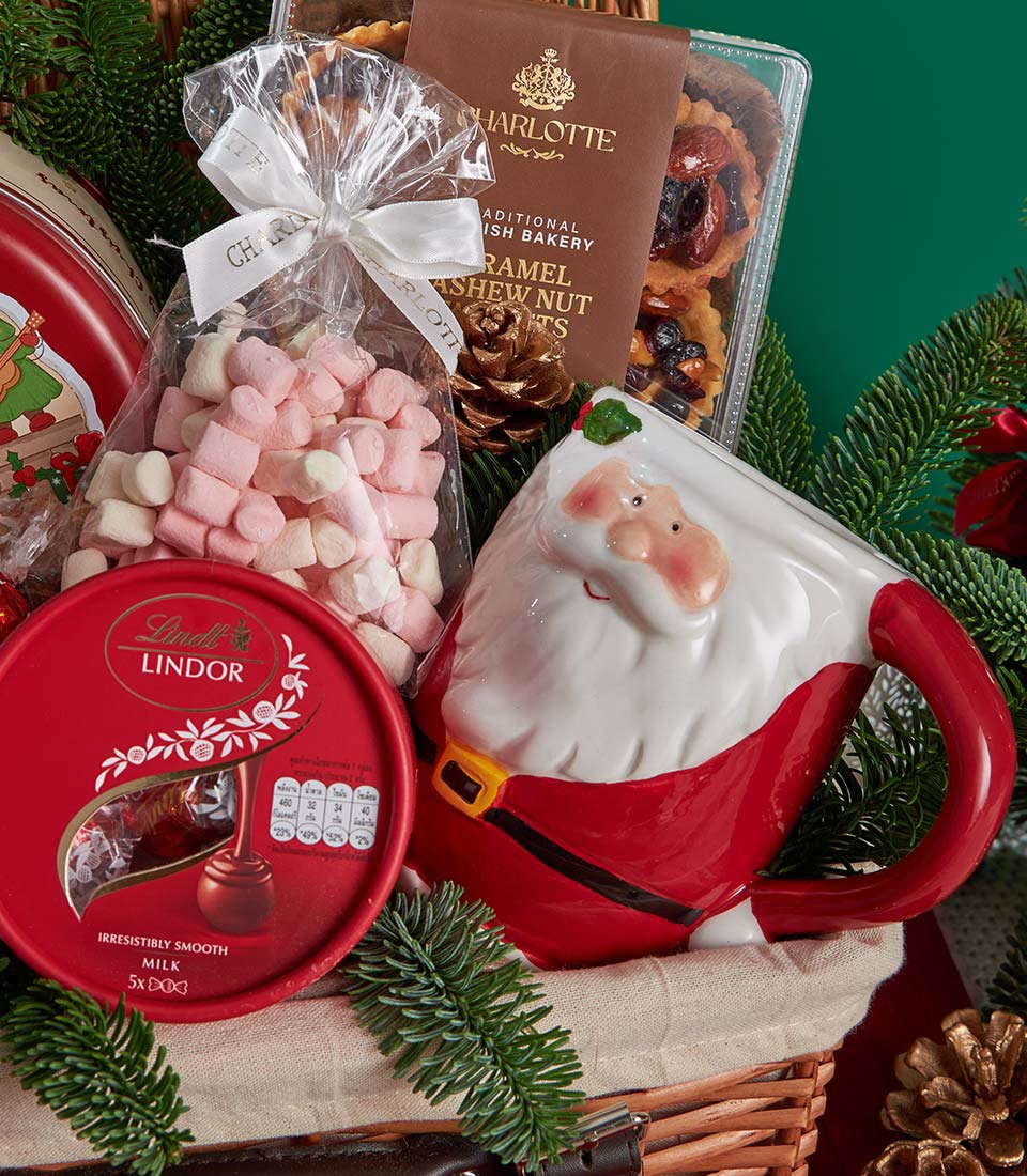 Festive Christmas gift basket with Lindor chocolates, marshmallows, Santa mug, and artisan bakery treats