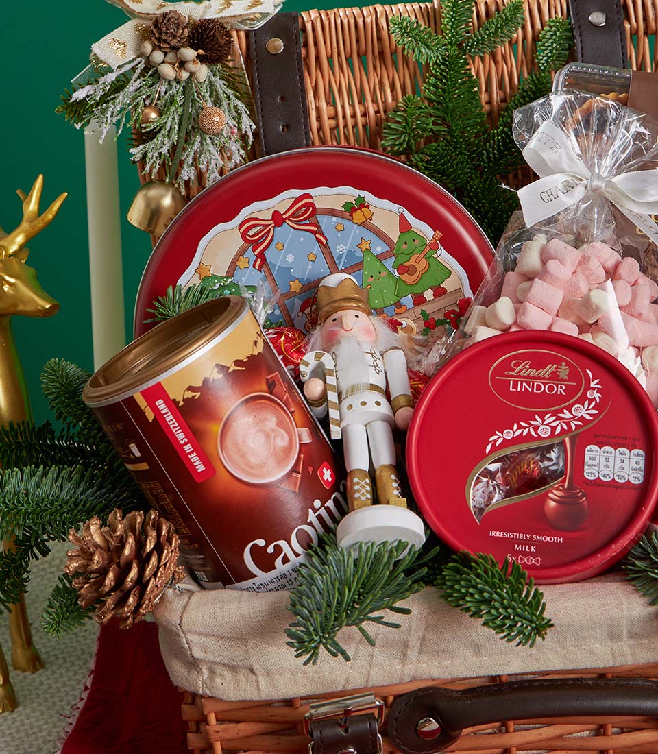 Festive Christmas gift basket with Swiss hot chocolate, milk chocolates, marshmallows, nutcracker, and holiday treats