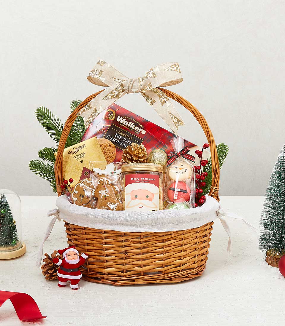 Festive Christmas gift basket with Scottish biscuits, cocoa, gingerbread cookies, and holiday treats in woven wicker