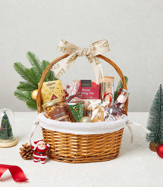 Festive Christmas gift basket with chocolates, tea, biscuits, and holiday treats tied with gold ribbon