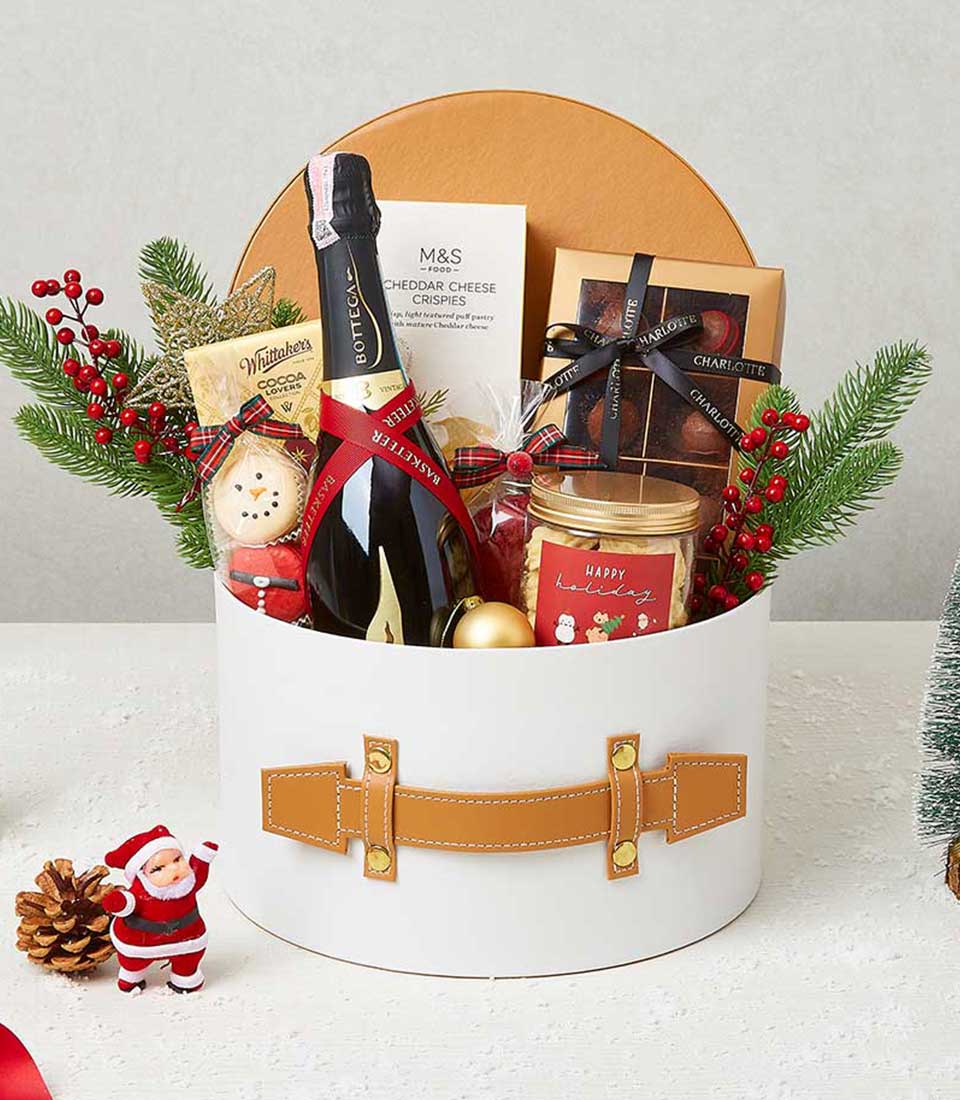 Luxury Christmas hamper with sparkling wine, gourmet cheese crisps, chocolate, and festive treats in white gift box with