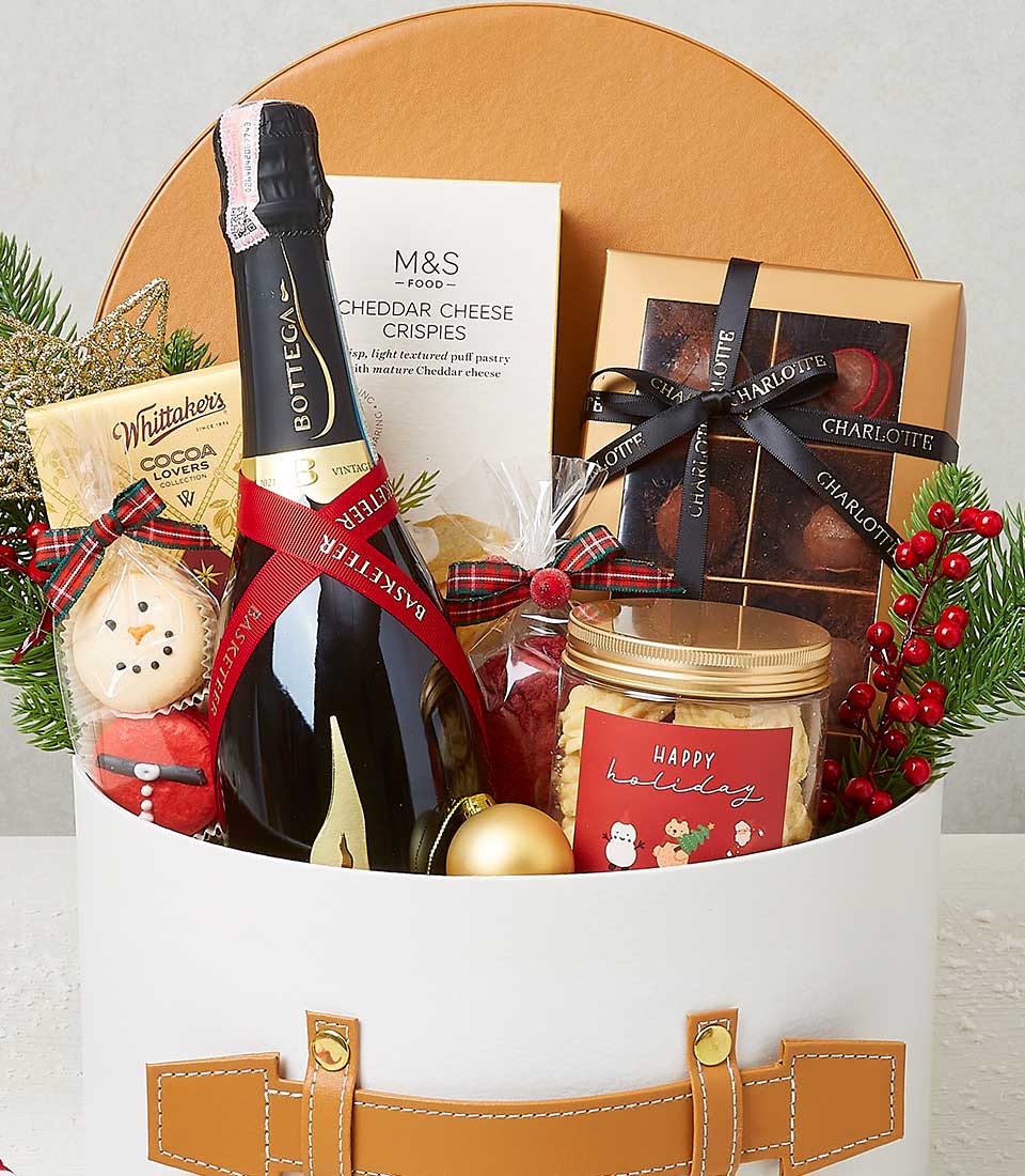 Luxury Christmas gift hamper with champagne, gourmet chocolates, cheese crisps, and festive treats in white cylindrical box