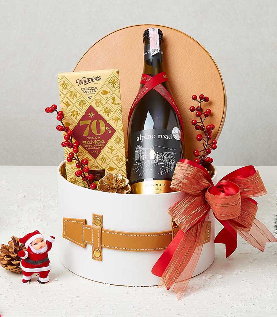 Festive wine hamper with Prosecco, dark chocolate, and red ribbon in white cylindrical gift box