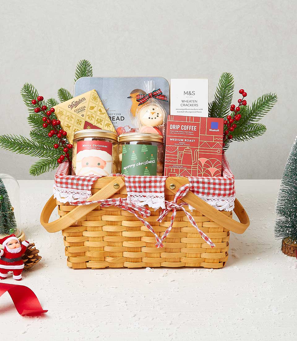 Woven wood Christmas hamper with gingham trim filled with gourmet treats, festive jars, artisan coffee, and crackers