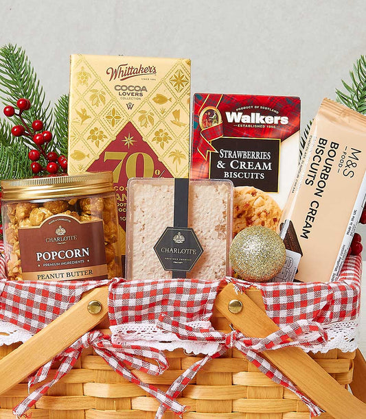 Festive woven gift basket with red checkered linen, gourmet biscuits, popcorn spread, and holiday ornaments
