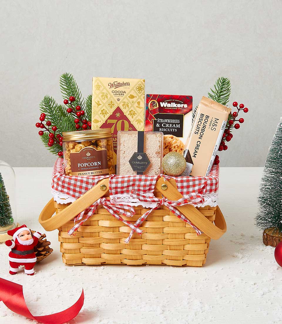Festive wicker gift basket with gourmet chocolates, biscuits, popcorn and honeycomb, tied with red gingham ribbon