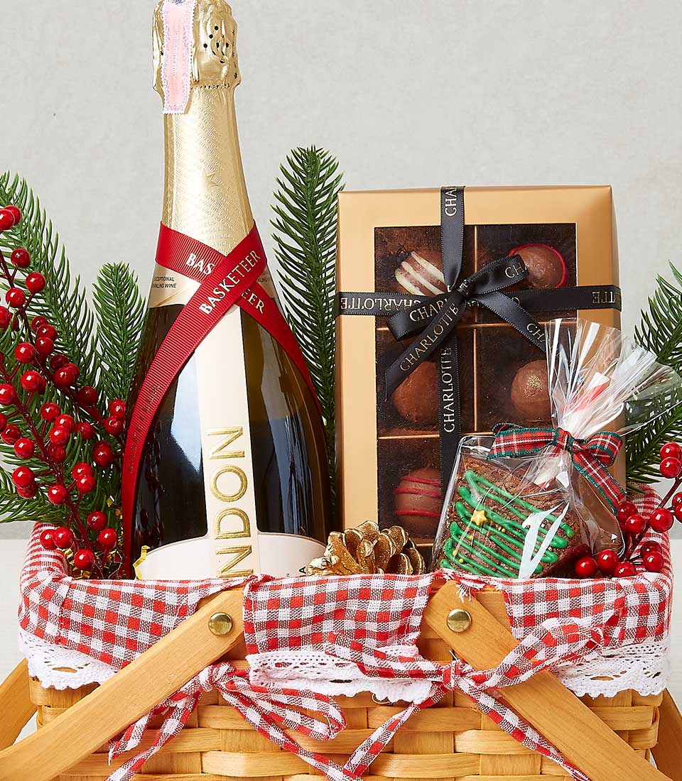 Festive woven basket with champagne, gold chocolates, and gingerbread cookie for Christmas gifting