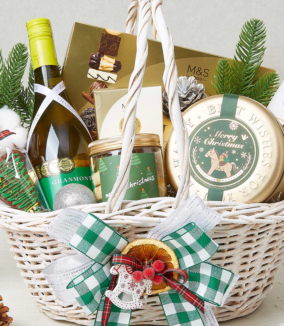Festive white wicker Christmas hamper with award-winning white wine, Belgian chocolates, and gourmet treats tied with green