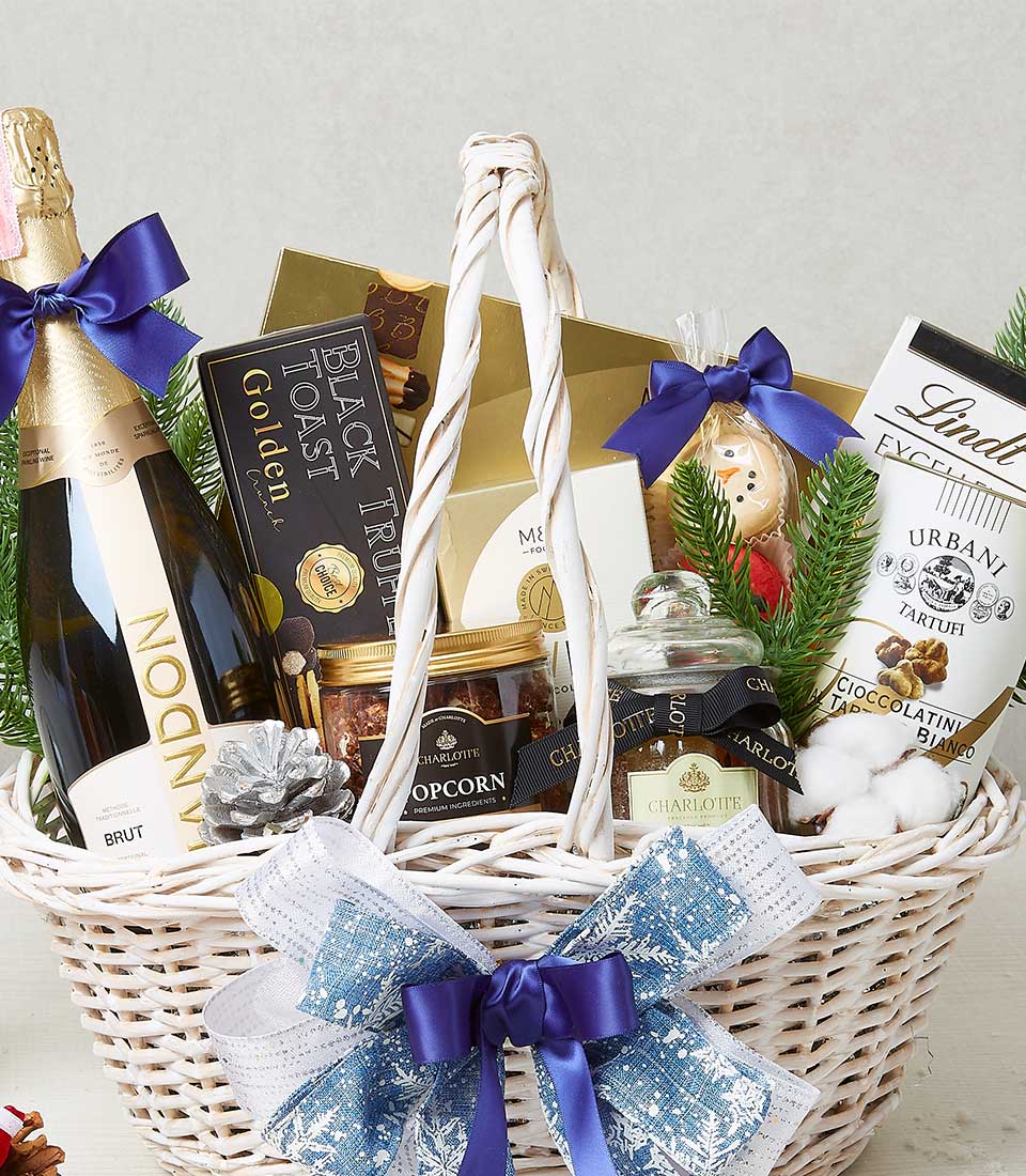 Premium white woven Christmas hamper with sparkling wine, dark chocolate, truffle popcorn, and festive holiday treats