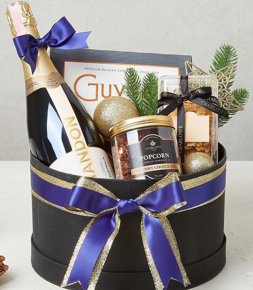 Luxury holiday wine and gourmet snacks gift hamper with champagne, chocolates, and festive gold accents