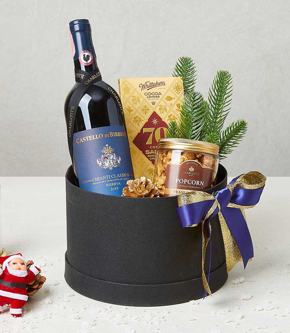 Luxury Christmas wine gift box with red wine, Whittaker's chocolate, and gourmet popcorn in elegant black packaging