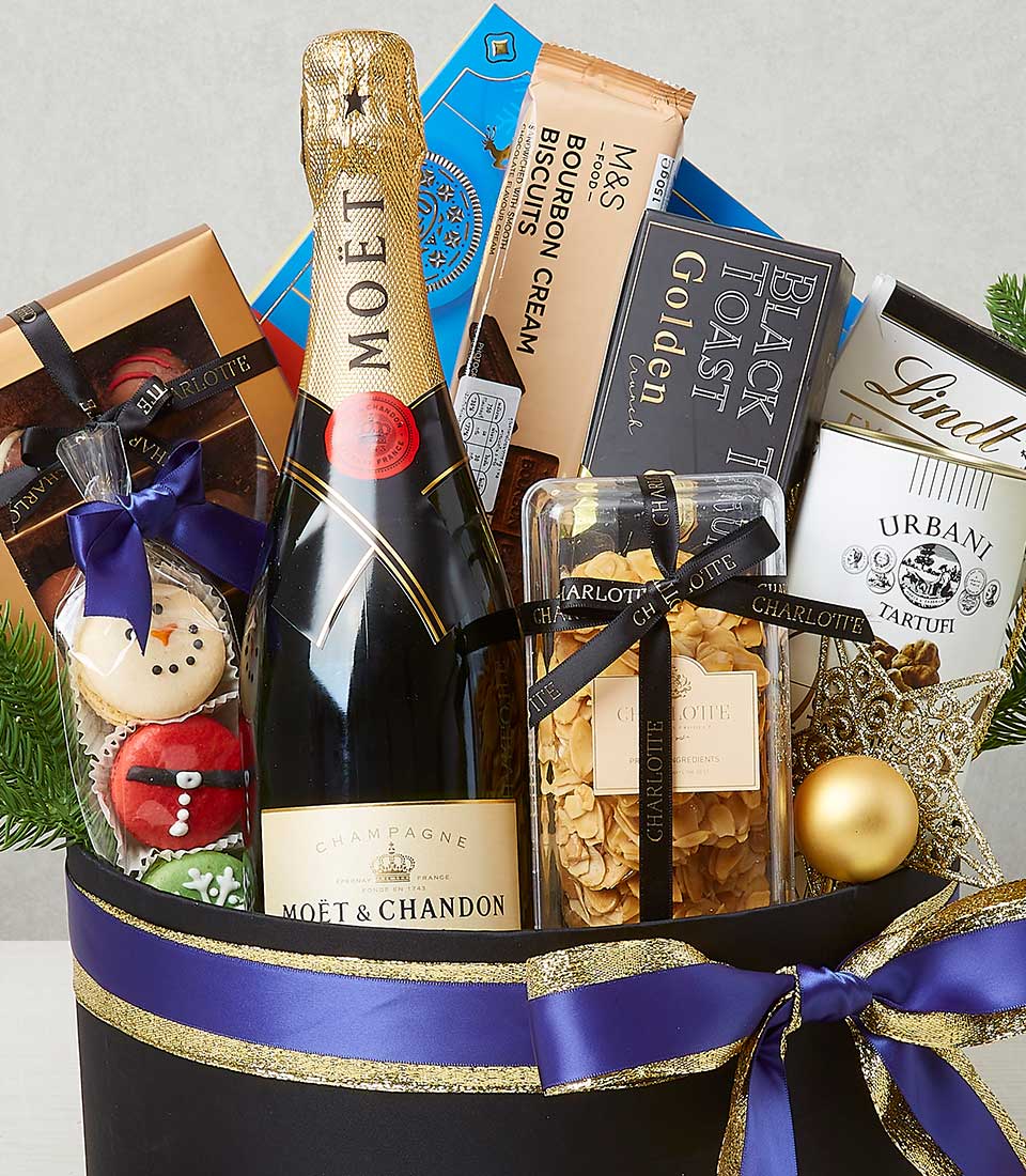 Luxury champagne and gourmet confections gift hamper with gold accents and festive decorations