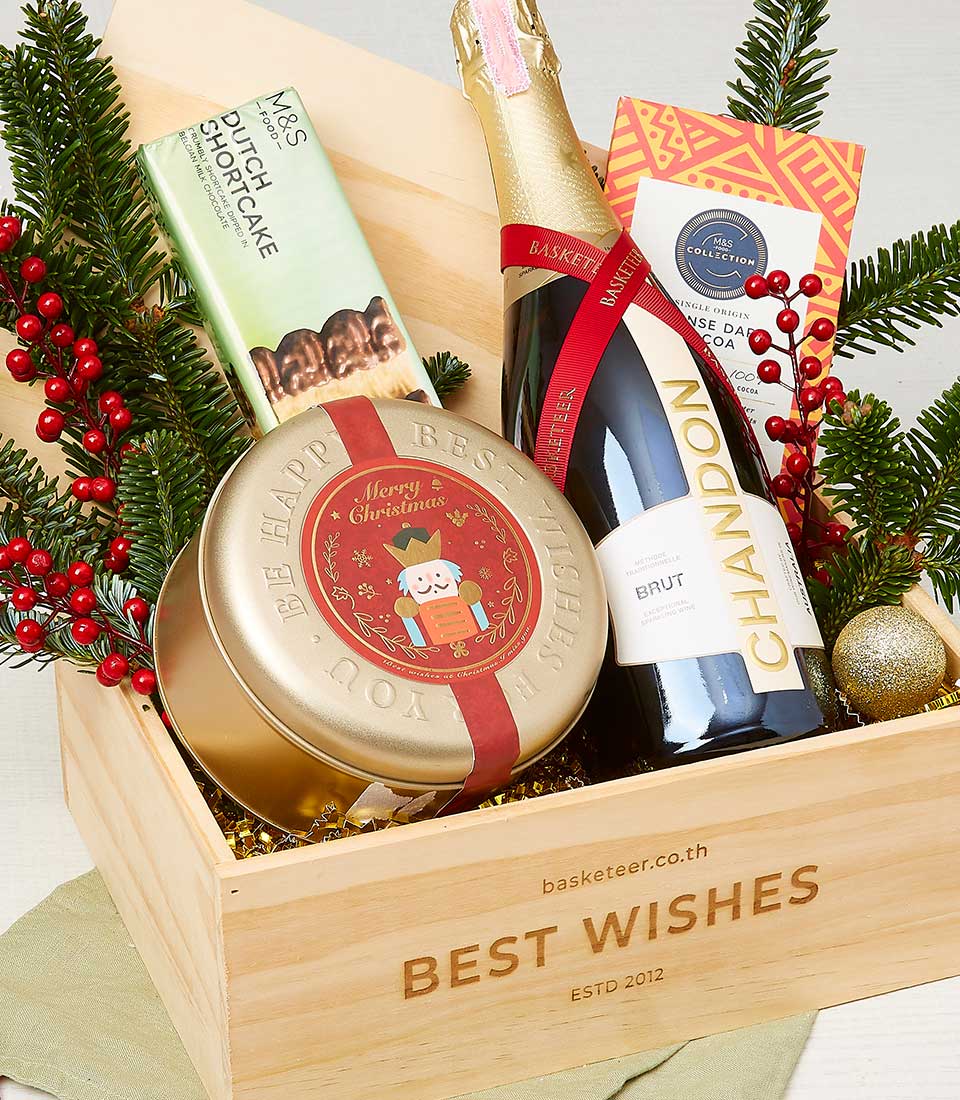 Festive Christmas wine gift basket with sparkling wine, shortbread, chocolate and gold nutcracker tin in wooden crate