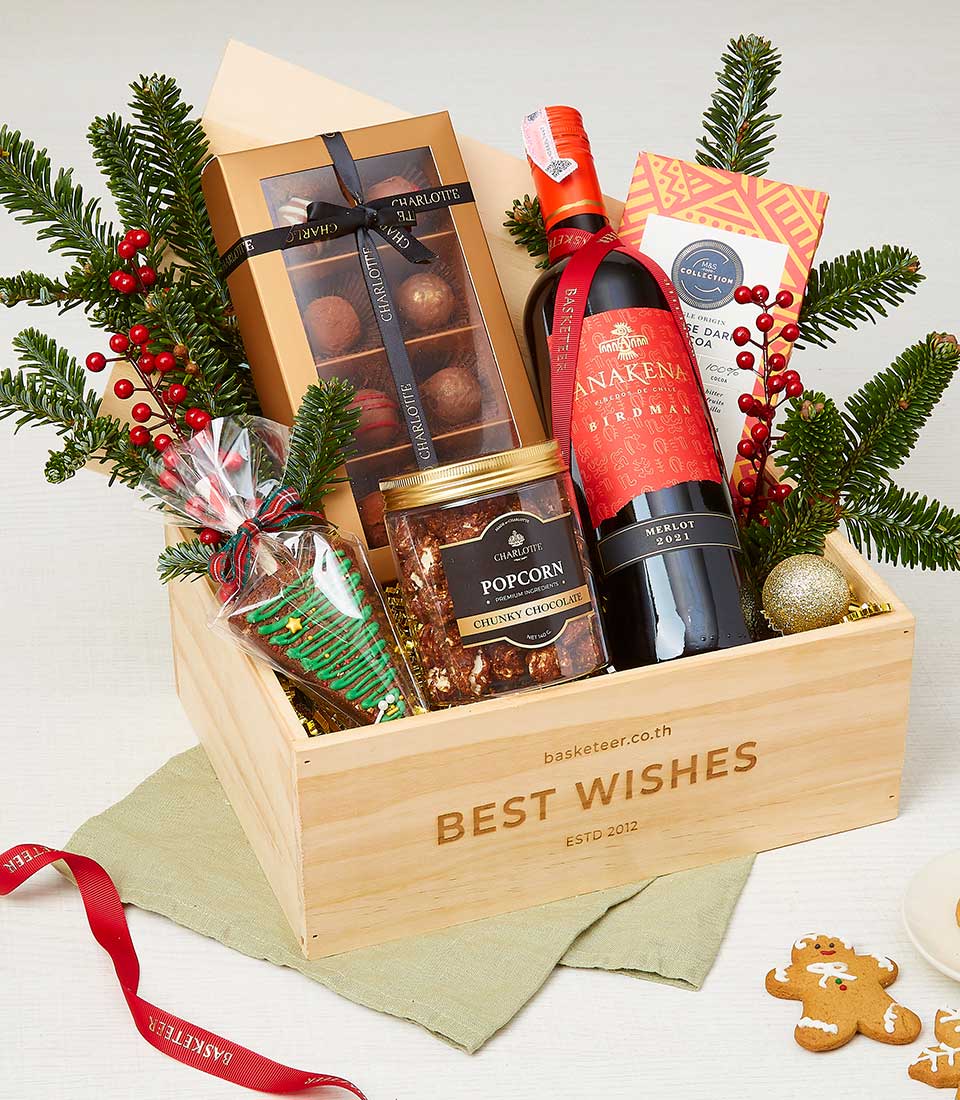Deluxe Christmas wine hamper with Merlot, chocolate truffles, gourmet popcorn, and festive treats in wooden crate