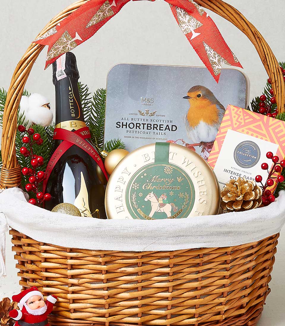 Festive wicker Christmas gift basket with sparkling wine, Scottish shortbread, dark chocolate, and gold ornaments