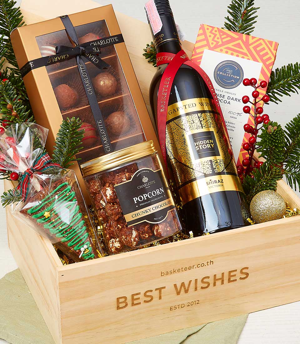 Gourmet Christmas wine basket with red wine, chocolates, and festive treats in wooden crate