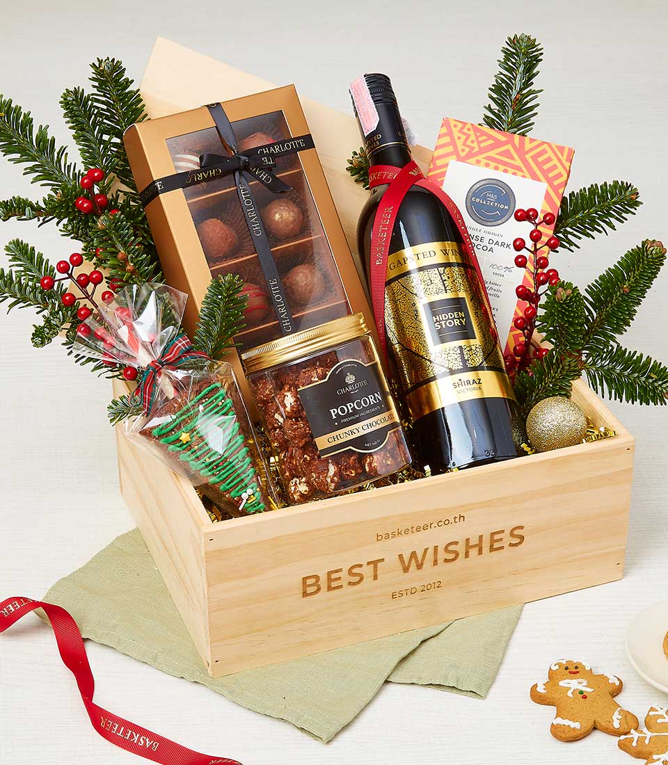 Festive Christmas wine gift basket with Shiraz, luxury chocolates, popcorn, and holiday treats in wooden crate