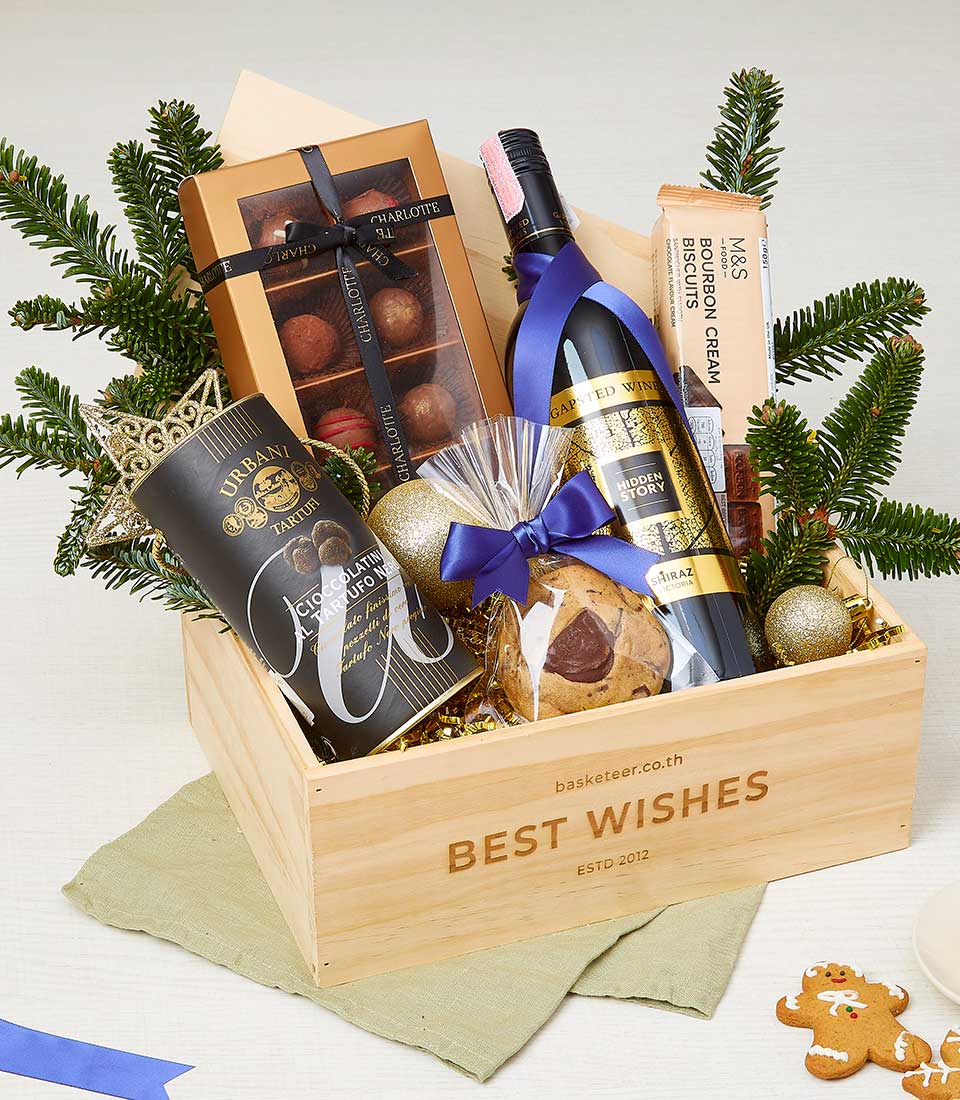 Festive wooden crate gift hamper with red Shiraz wine, Charlotte chocolates, truffle treats, and holiday greenery