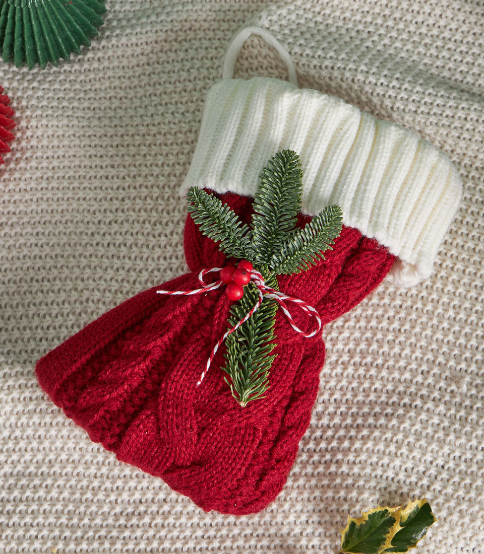 Festive Basketeer Christmas gift in a red knitted stocking tied with baker's twine and evergreen sprig. Perfect for same-day hamper delivery in Bangkok.