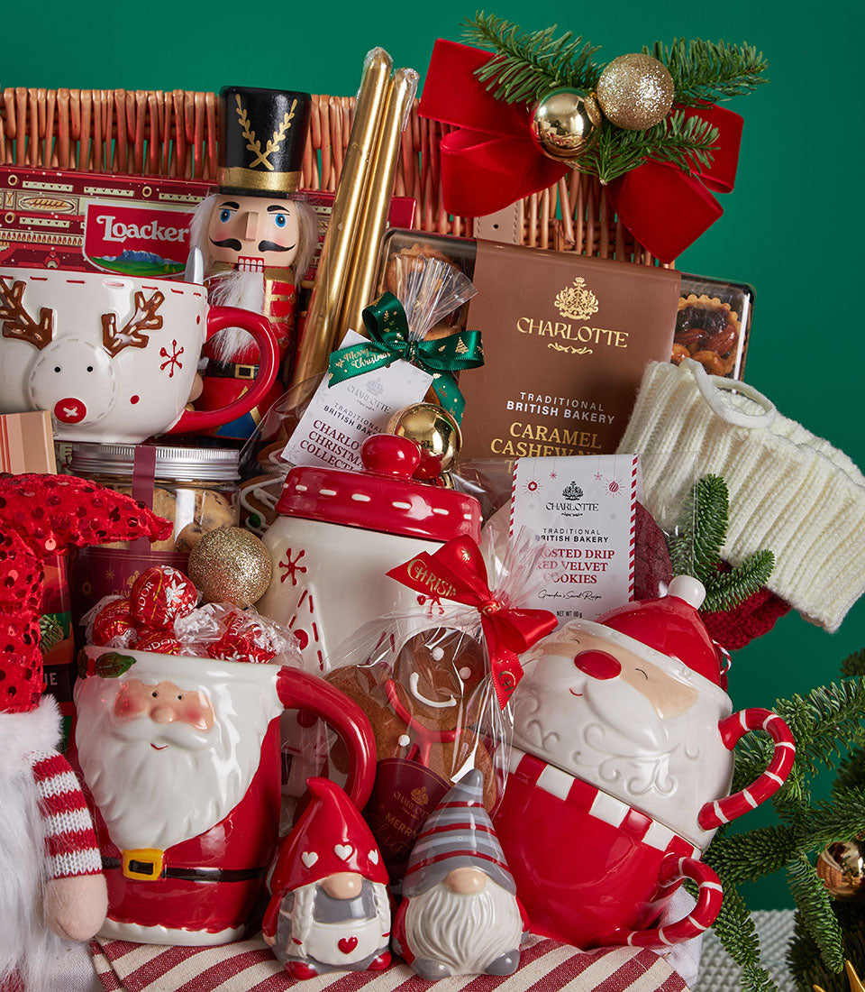 Festive Christmas gift basket with reindeer mug, wooden nutcracker, Charlotte bakery treats, and holiday decorations