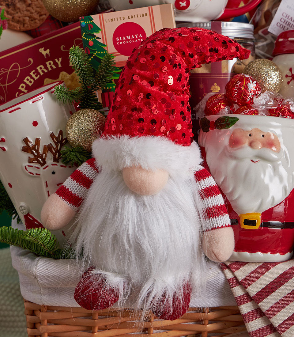 Festive Christmas gift basket with gnome plush, reindeer mug, Santa container, chocolates, and holiday ornaments