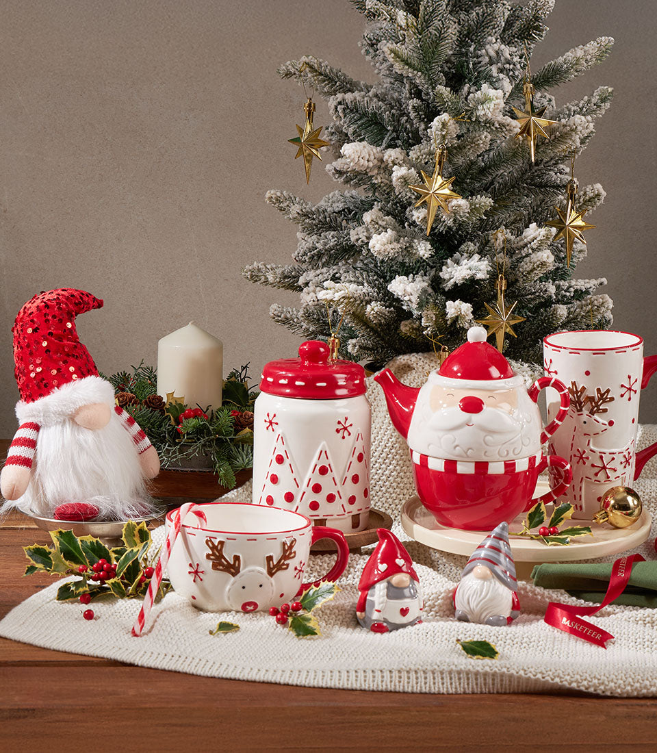Festive Christmas homeware gift basket with ceramic cookie jar, Santa teapot, reindeer mugs, gnomes, and candle