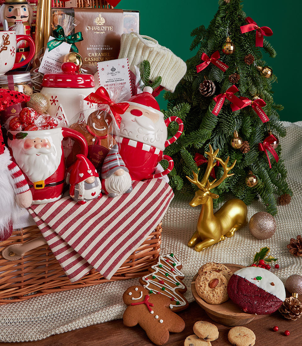 Premium festive Christmas gift basket with gingerbread cookies, caramel cashew tart, Santa mug, and holiday decorations