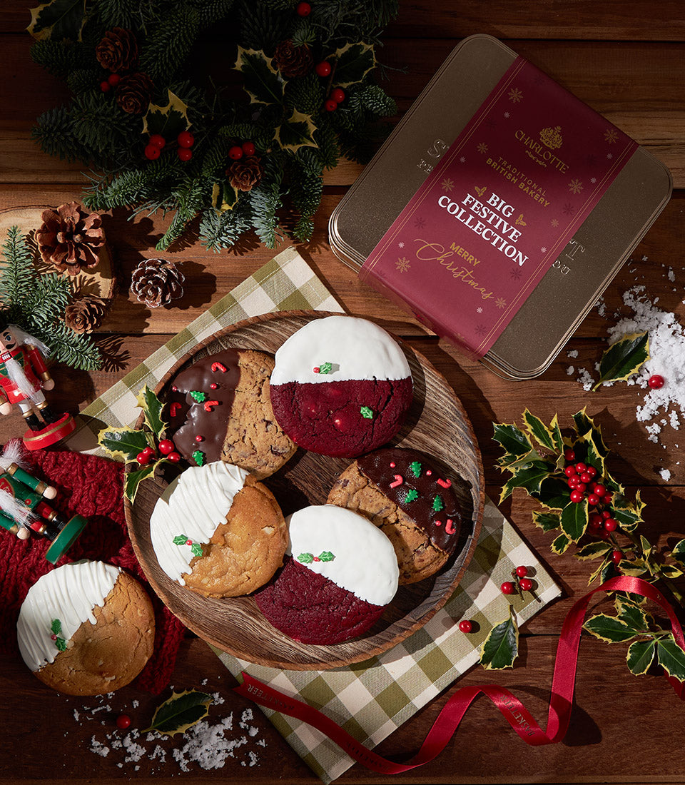 Festive British soft cookies with chocolate and holly sprinkles, gold Christmas tin gift set on rustic wood