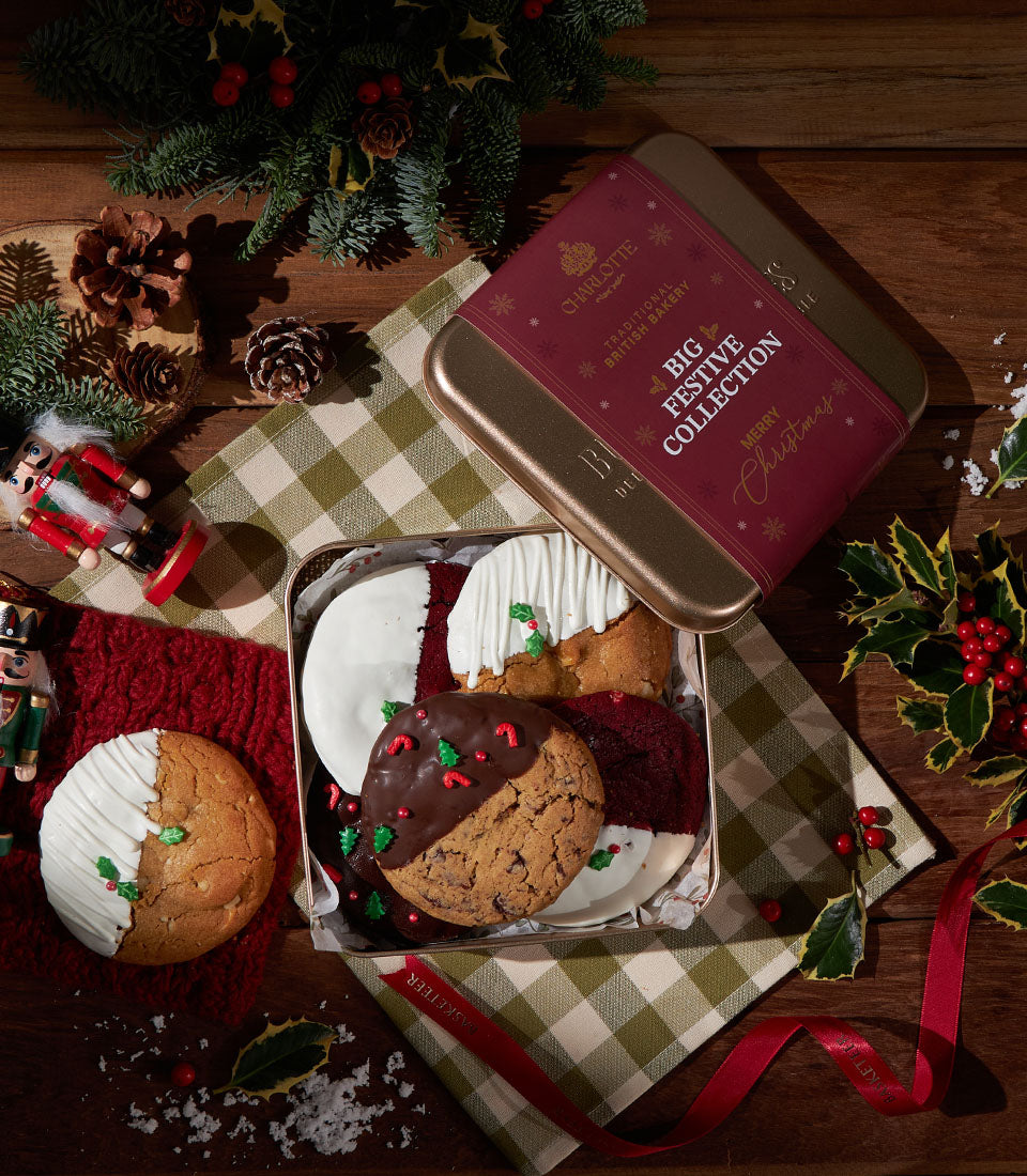 Festive British soft cookies in gold and maroon holiday tin with white and dark chocolate icing and holly decorations