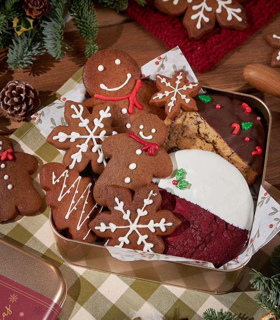 Festive Christmas cookie tin with gingerbread men, snowflakes, and red velvet treats in white icing