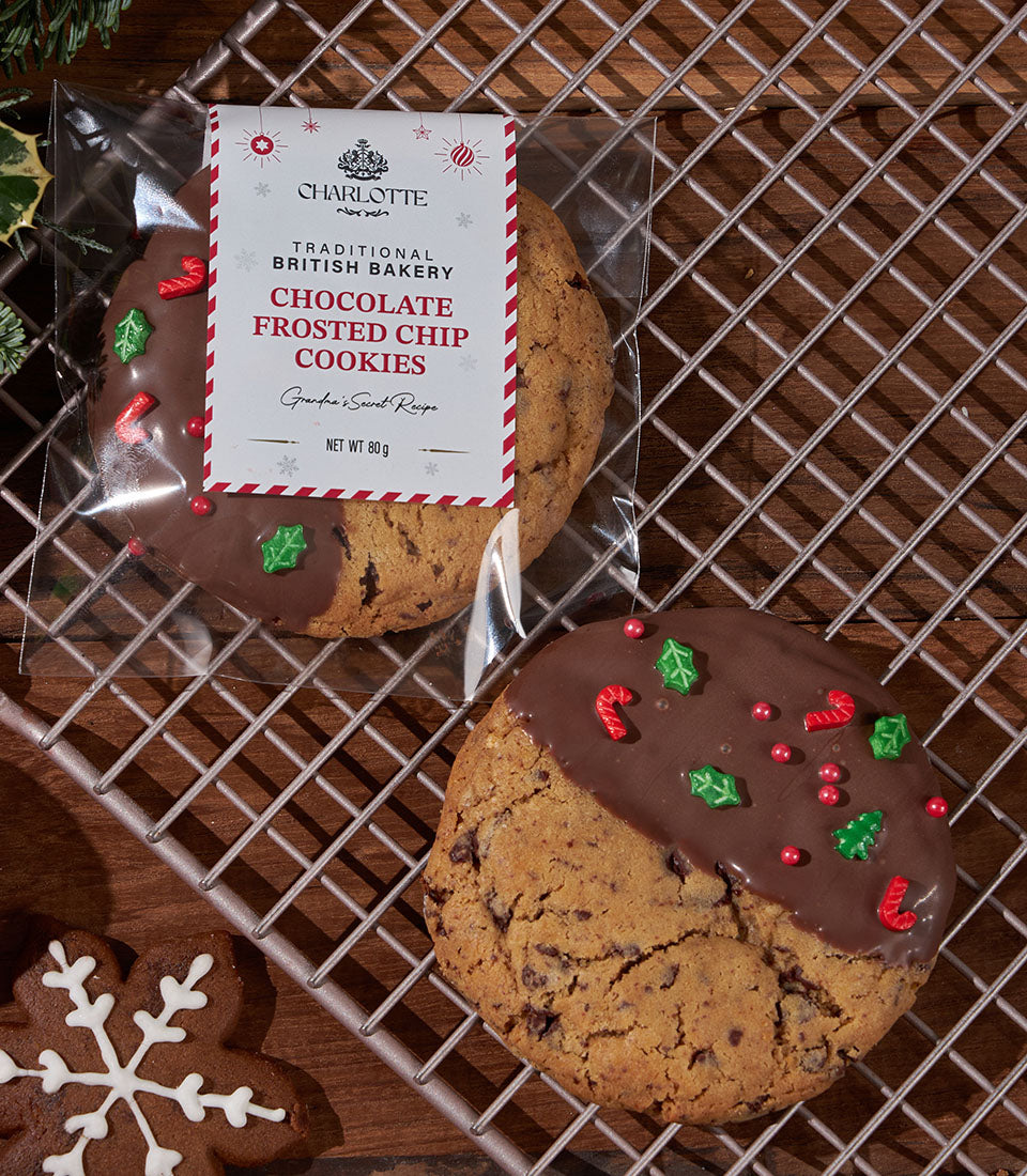 Festive chocolate chip cookies with candy cane and holly decorations on cooling rack