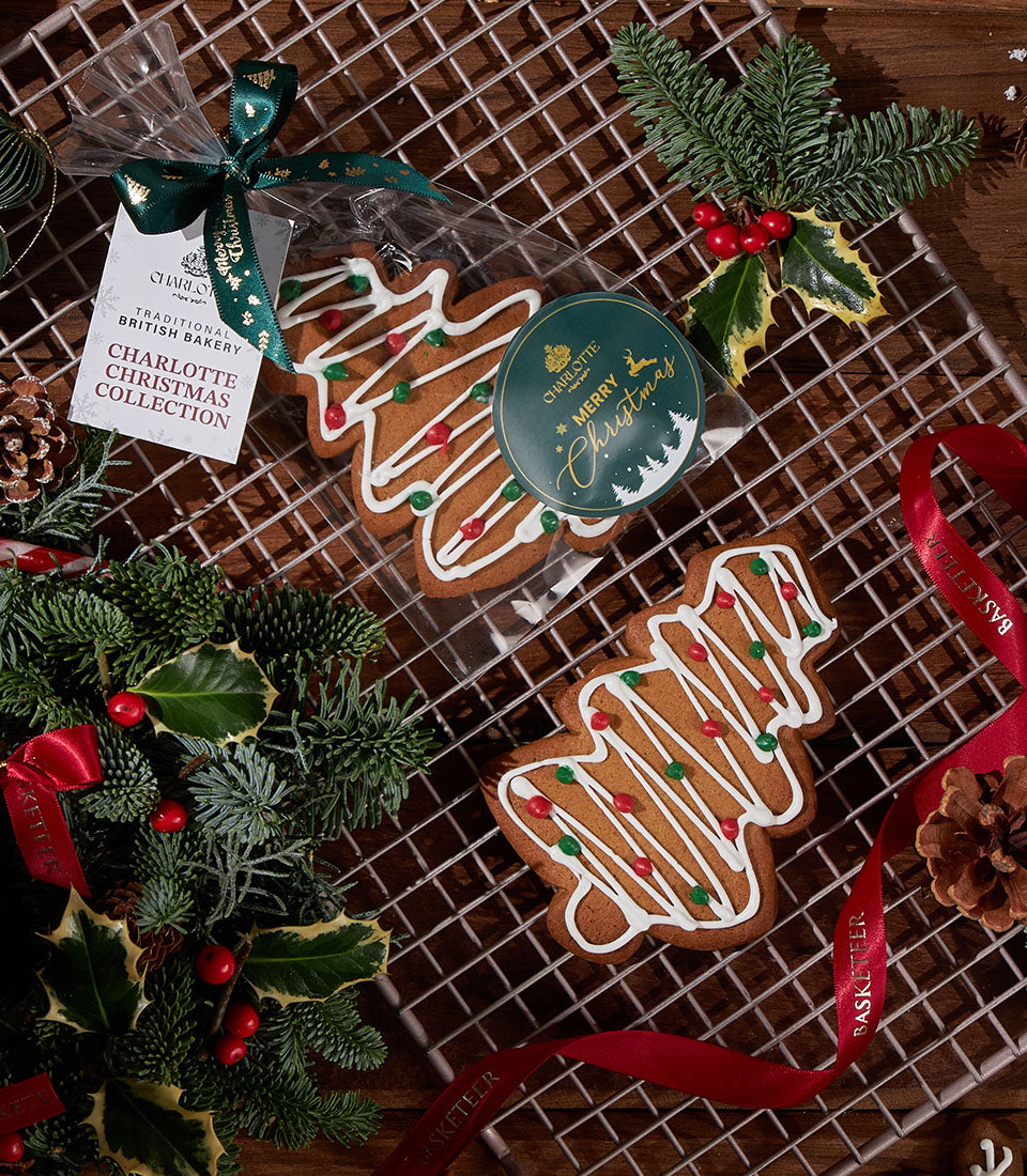 Christmas tree gingerbread cookies with white icing and candy decorations in festive packaging with green ribbon