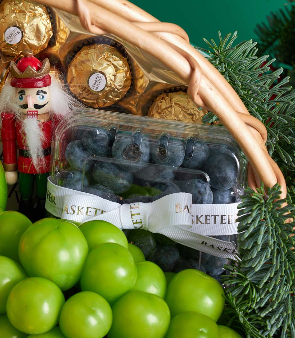 Luxury Christmas fruit basket with Ferrero Rocher chocolates, fresh blueberries, green plums, and festive nutcracker