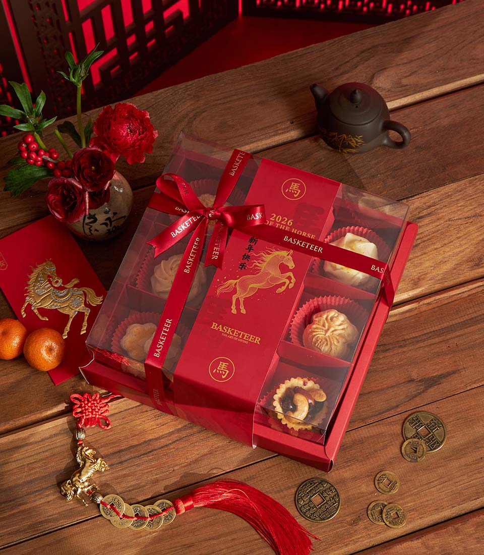 Red Chinese New Year bakery gift box with nine gourmet pastry compartments, red ribbon, and lucky horse charm tag