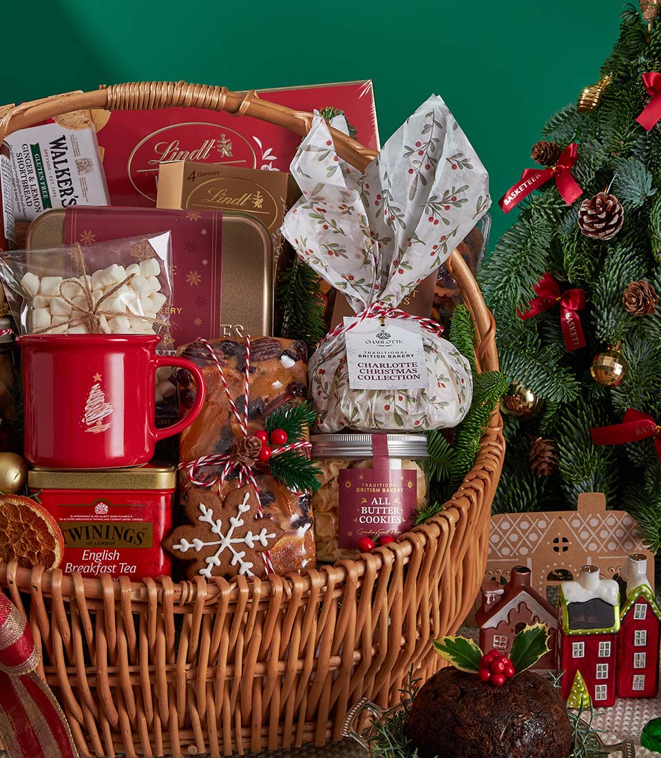 Woven wicker Christmas gift basket with English Breakfast tea, artisan chocolates, marshmallows, and festive baked goods