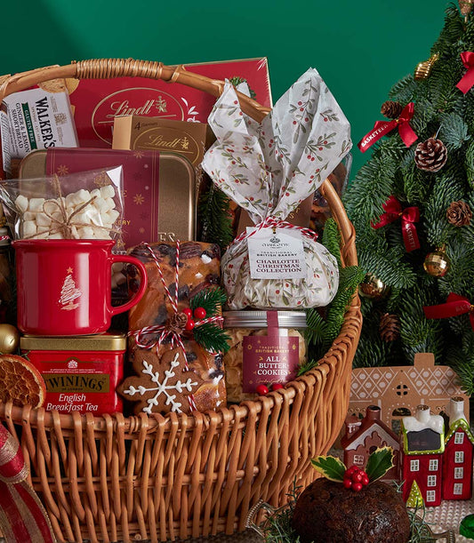 Woven wicker Christmas gift basket with English Breakfast tea, artisan chocolates, marshmallows, and festive baked goods