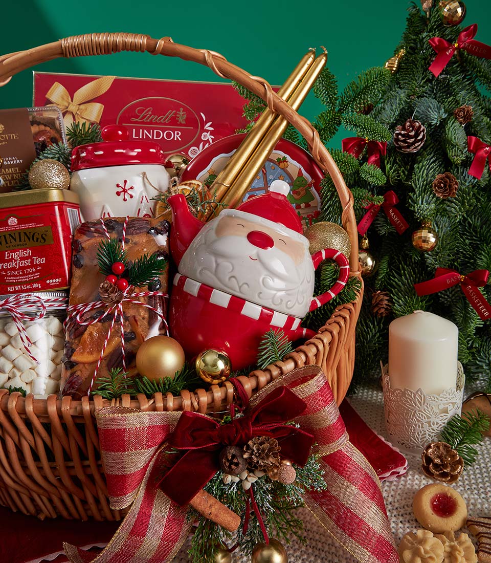 Luxury Christmas gift basket with Lindt chocolates, Twinings tea, fruitcake, marshmallows, Santa teapot, and gold accents
