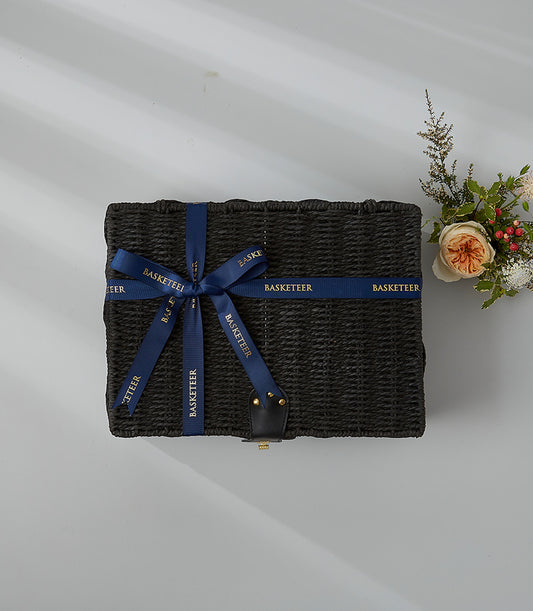Black luxury wicker hamper with peach rose and gold-ribbon detail for premium gift giving