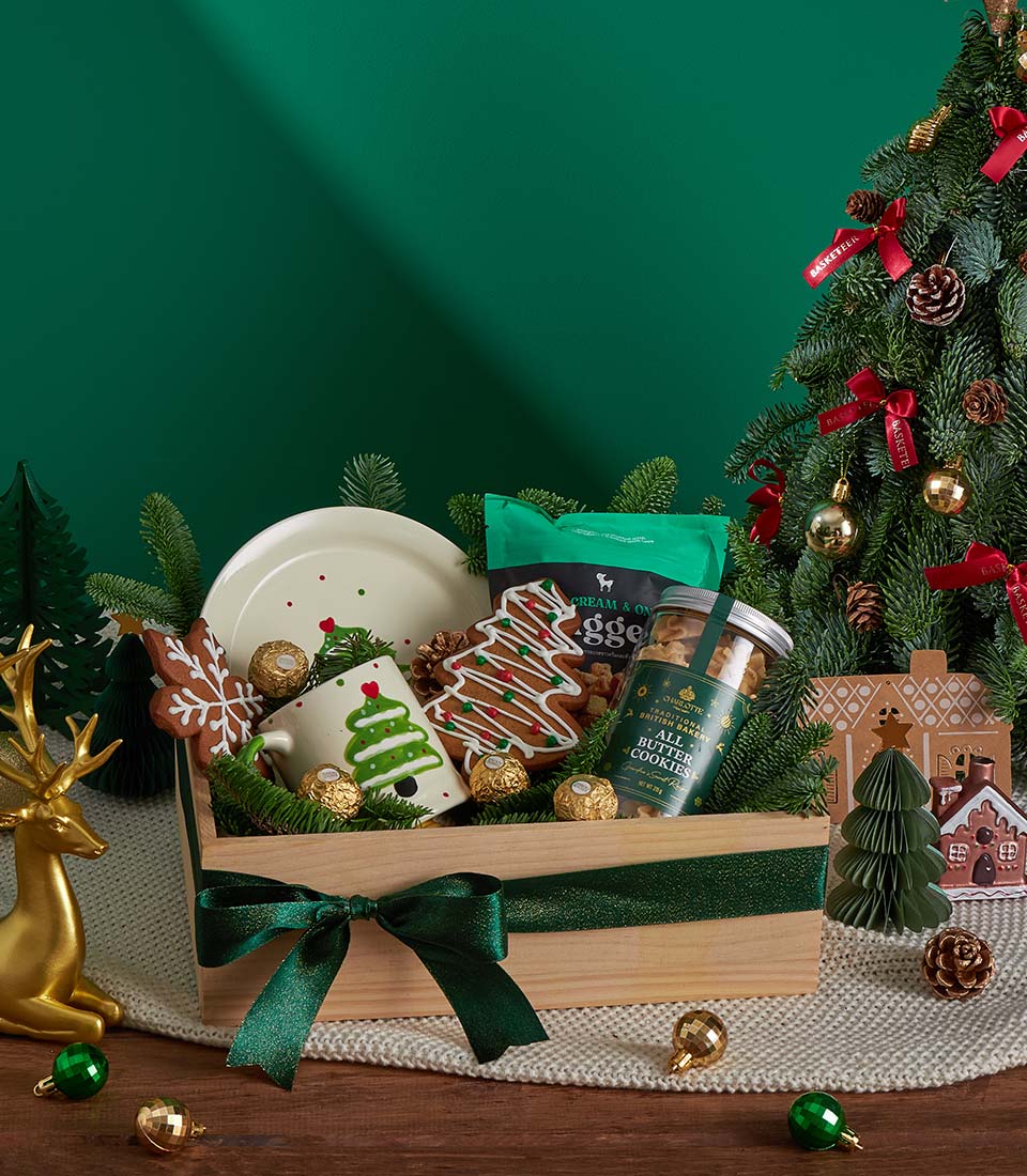 Festive Christmas gift box with cookies, mug, and holiday treats tied with green ribbon