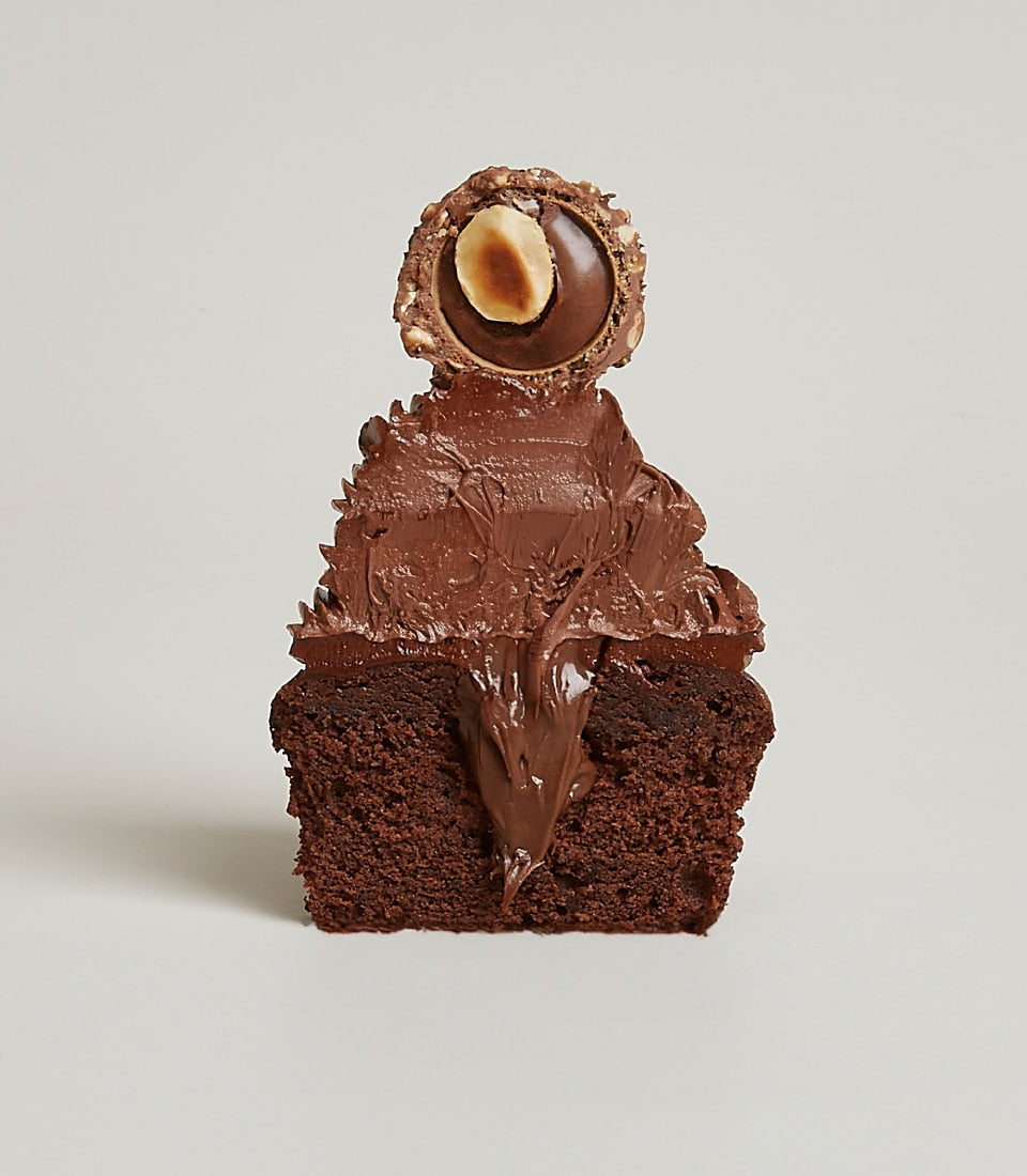Chocolate cupcake with hazelnut praline, chocolate ganache filling, and creamy frosting swirl