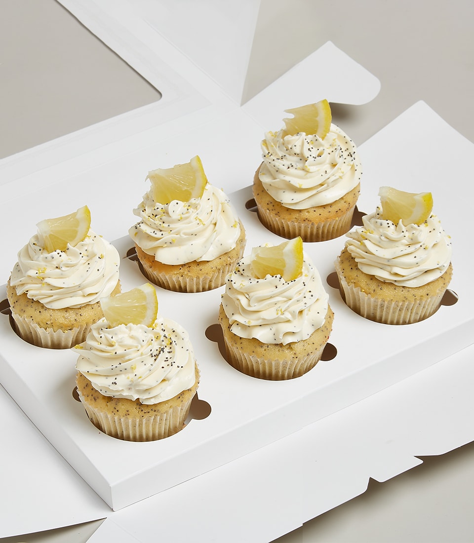 Lemon poppy seed cupcakes with white frosting and candied lemon in luxury gift box
