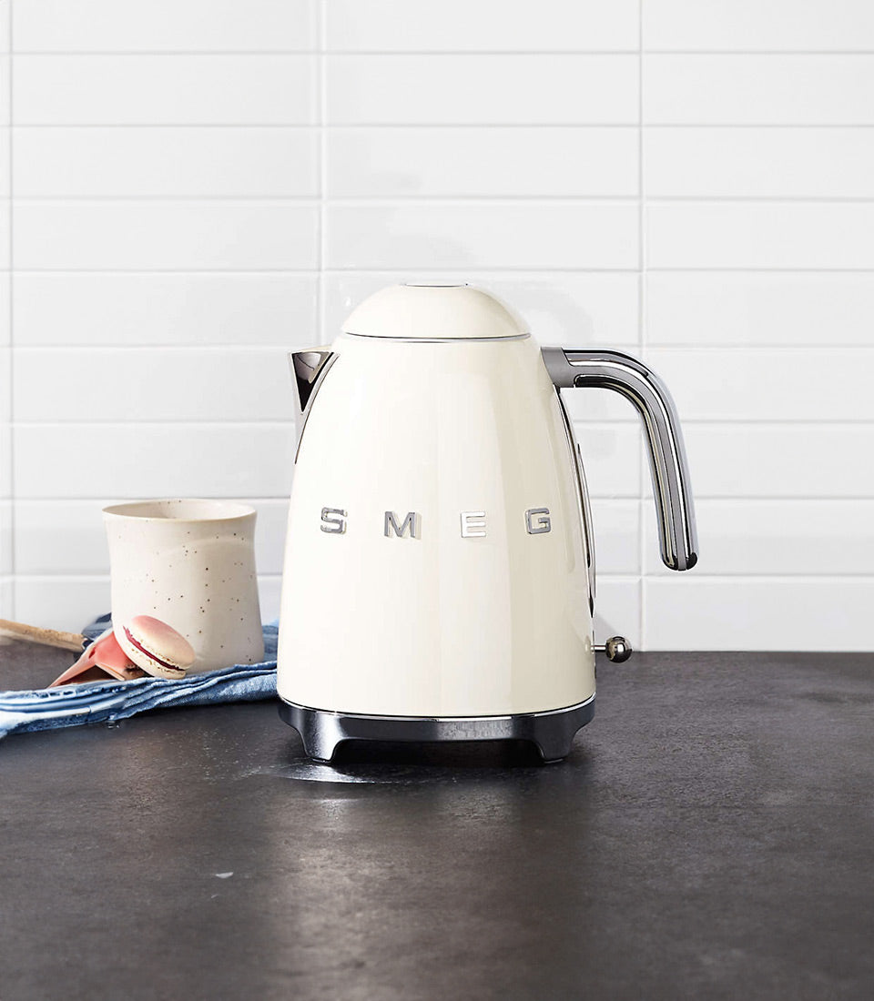 Cream SMEG retro electric kettle with chrome handle, styled new home gift with ceramic mug and macaron
