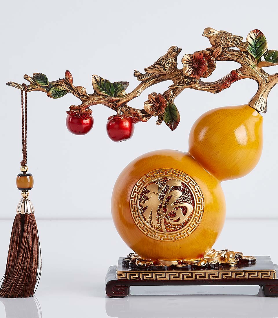 Golden gourd ornament with persimmon branch, red fruits, and birds symbolizing good fortune and prosperity