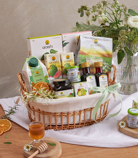 Woven wicker wellness gift basket with guava juice, health beverages, and gourmet treats, tied with green Basketeer ribbon