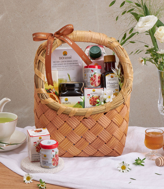 Doi Kham herbal wellness gift basket with lemongrass drink, pomegranate preserve, and natural remedies in woven wicker