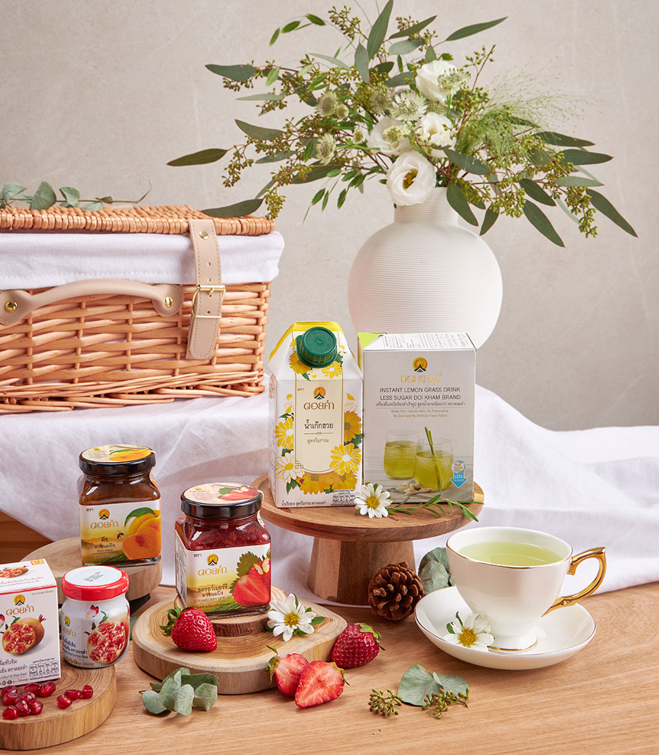 Premium wellness gift hamper with herbal drinks, honey preserves, and fresh flowers in wicker basket