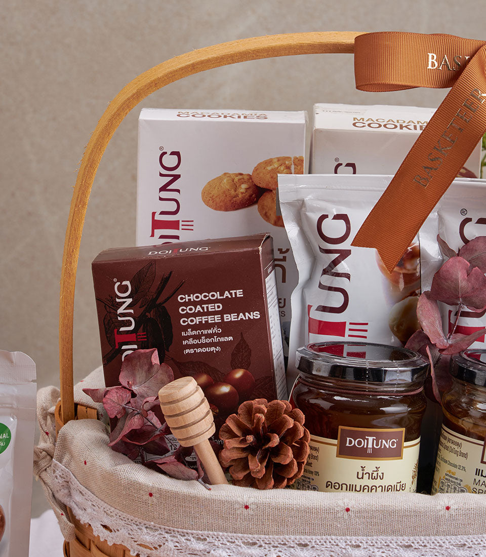 Woven gift basket with DoiTung macadamia cookies, honey, chocolate coffee beans, and dried florals