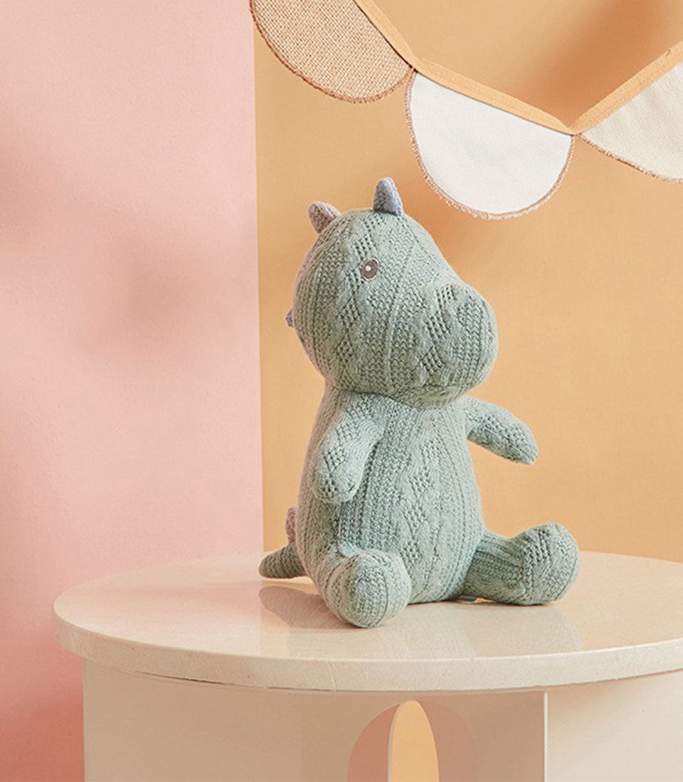 Light green crocheted dinosaur soft toy with textured knit and button eyes, ideal for baby gifts